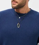 Conjunto de dos collares, uno de cadena metálica fina con dije de piedra orgánica y otro de cordón con colgante metálico de forma irregular.