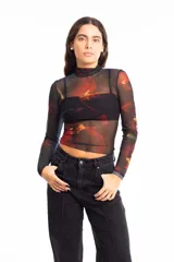 Remera de mesh transparente con cuello alto y estampado floral en tonos rojos y azules.