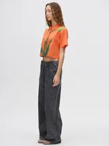 Camisa corta celeste con estampado de nubes, cuello clásico, manga corta y cierre frontal con botones.