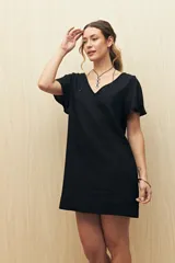 Vestido corto negro con escote en V y mangas cortas con volados.