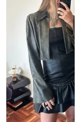 Vestido strapless de cuero ovino color negro, con volados y detalles de pequeñas piedras brillantes.