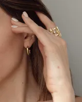 Aros de diseño minimalista con forma de argolla pequeña, realizados artesanalmente en bronce y alpaca con pernos de plata 925.