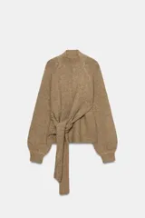 Jersey de punto con cuello perkins, manga larga con puños ajustados y detalle de lazada en la cintura.