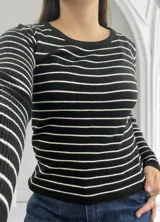 Sweater de punto a rayas horizontales blancas y negras, de manga larga y cuello redondo.
