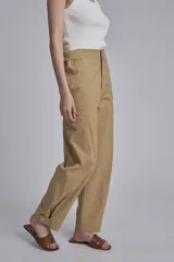 Pantalón color beige con tachas plateadas, tiro alto y corte recto.