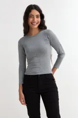 Remera de manga larga con cuello redondo a la base, confeccionada en algodón, de corte ajustado al cuerpo.