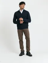 Cardigan de punto color marrón, con cuello alto y cierre frontal completo. Presenta mangas largas tipo ranglan y bolsillos laterales de ribete.