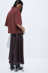 Remera polo de corte holgado confeccionada en piqué de algodón, con mangas al codo, hombros caídos y cuello acanalado. Presenta tapeta con botones y bajo recto con aberturas laterales.