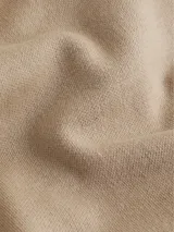 Sweater color beige de lana con escote en v, mangas largas y hombros caídos. Presenta logo de Calvin Klein en la parte superior trasera.