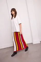 Falda larga tejida a rayas verticales en tonos azul, blanco, negro y bordó, con cintura elástica.