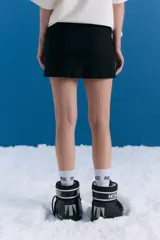 Minifalda de tiro medio confeccionada en bengalina lisa, con cintura ancha, cierre invisible lateral y bolsillos ojal decorativos en el frente.