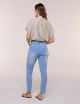 Jean slim skinny de tiro medio en denim azul con proceso de lavado, calce ajustado y largo al tobillo. Cuenta con pretina con presillas, bolsillos delanteros y traseros, y acceso frontal con botón y cierre.