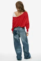 Jeans de tiro medio y corte baggy con cinco bolsillos, trabillas y rotos decorativos. Cuenta con detalle de cinturón confeccionado en el mismo tejido y cierre frontal con cremallera y botón metálico.