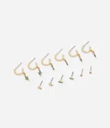 Set de seis pares de aros dorados. Incluye tres pares de aros tipo argolla con dijes colgantes de strass de colores y tres pares de aros pequeños tipo punto de luz con cierre a rosca.