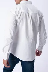Camisa de vestir manga larga color blanco, con cuello clásico abotonado y bolsillo frontal en el pecho. Diseño de corte recto y puños ajustables con botones.