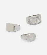 Kit de tres anillos femeninos de metal plateado con diferentes diseños que combinan superficies lisas, arabescos y texturas.