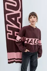 Bufanda de tejido jacquard con diseño de rayas horizontales anchas en color marrón chocolate y rosa. Presenta una textura suave y un estilo envolvente.