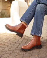 Botas tipo chelsea de cuero color marrón óxido, con paneles laterales de textura combinada y suela track negra de goma.