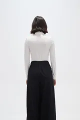 Polera de poliamida ajustada al cuerpo, con cuello alto y mangas largas.