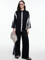 Camisa de lino roja con silueta amplia y mangas 3/4. Diseño con tiras de color rosa en contraste en la cartera, mangas y cuerpo. Tiene tajos laterales y ruedo irregular en el frente.