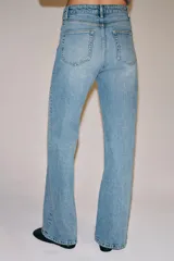 Jeans wide leg de tiro alto y diseño de cinco bolsillos, con efecto lavado, trabillas en la cintura y cierre frontal con cremallera y botón metálico.