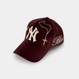Gorra tipo baseball color marrón con bordado frontal del logo NY y bordado lateral de una paloma. Cuenta con cierre ajustable en la parte posterior.