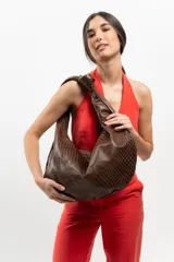 Bolso tipo hobo de cuero marrón con textura de piel de cocodrilo, asa anudada y cierre superior abierto.