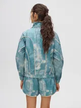 Short holgado de estilo boxy, color celeste con estampado tie-dye y detalles de ribetes en tono crudo. Cuenta con pretina elástica y pequeño logo bordado en la pierna.