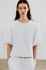 Camiseta blanca de algodón con cuello redondo y mangas cortas abullonadas.