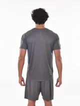 Remera deportiva de manga corta, color gris claro con sutil textura de rayas horizontales. Presenta cuello redondo y costuras reforzadas en los hombros.