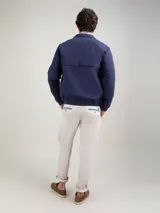 Campera Harrington color beige, con cuello alto abotonado, cierre frontal completo y bolsillos laterales con solapa y botones a presión. Puños y cintura elastizados de rib.