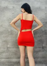 Vestido corto rojo ajustado, con breteles finos y detalle de frunce lateral con lazos.