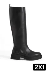 Botas de caña alta confeccionadas en cuero sintético color negro, con suela track de goma y cierre lateral.
