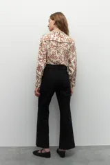 Pantalón ancho de tiro alto, color negro, con pretina y doble botón metalizado.