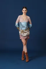 Vestido corto de manga larga con escote en V, caracterizado por un estampado artístico que representa un paisaje montañoso con ciervos en la parte inferior.