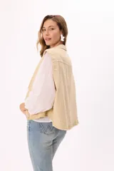 Chaleco estilo cargo color marrón, con cuello camisero, cierre frontal de botones negros y dos bolsillos frontales con solapa. Presenta detalles de terminaciones desflecadas en el ruedo y en los bolsillos.