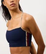 Top deportivo Get Over con diseño de espalda nadador y breteles finos en color beige contrastante. Confeccionado en microfibra técnica, cuenta con copas incorporadas para mayor sujeción y ajuste al cuerpo.