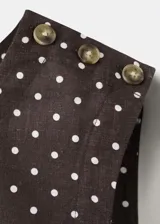 Top crop marrón oscuro con estampado de lunares blancos, cuello redondo y tirantes anchos.
