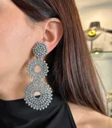 Aros colgantes con forma circular, hechos con cristales grises tramados y ajuste de clip.