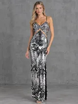 Vestido largo y ajustado de lentejuelas grandes en tonos negro y plateado, con diseño sin mangas, breteles finos regulables, escote en V y detalles de transparencias en la cintura y espalda.