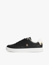 Zapatillas de corte bajo estilo tenis, confeccionadas en piel color negro. Presentan suela de goma blanca, detalle metalizado en el talón, ojal superior dorado y monograma TH metálico en el lateral.