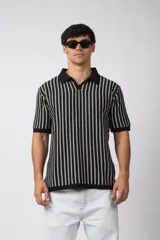 Chomba de punto con diseño de rayas verticales en color negro y blanco, cuello polo y manga corta con terminación acanalada.