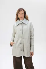 Campera de cuero tipo lambskin con diseño de paneles, cuello con solapas de piel sintética, cierre frontal con botones y bolsillos laterales.