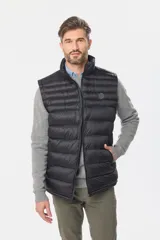 Chaleco negro capitoneado con cierre frontal y cuello alto.