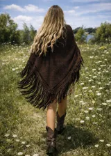 Ruana tejida a mano en lana merino, de color marrón chocolate, con diseño triangular y terminación de flecos largos en todo el borde.