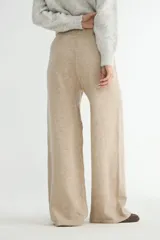 Pantalón tejido de corte recto y tiro alto, color beige, con cintura elástica ajustable mediante cordón y costura central vertical en cada pierna.