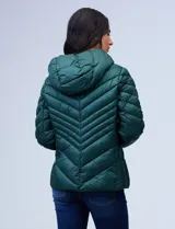 Campera de abrigo verde esmeralda, marca Michael Kors. Diseño acolchado con cierre metálico central, capucha no desmontable con cordón de ajuste y bolsillos verticales delanteros. Incluye bolsa autoportante.