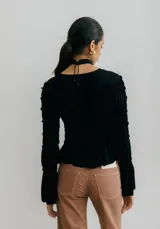 Top blanco fruncido con mangas largas acampanadas.