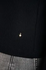 Remera negra de manga larga, con cuello redondo y tejido acanalado, de corte ajustado al cuerpo.