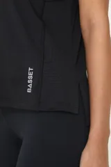 Remera deportiva negra de poliéster y elastano, con recortes laterales y traseros.